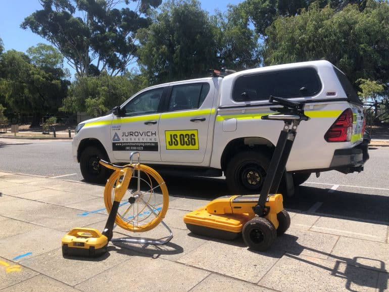 utility locating equipment in front of jurovich surveying vehicle